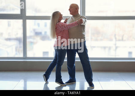 Ältere Paare tanzen in der Nähe der Fenster Cute Stockfoto