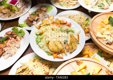 Viele Platten von Lebensmitteln auf dem Tisch. Kalte Vorspeisen und Salate im Restaurant Stockfoto