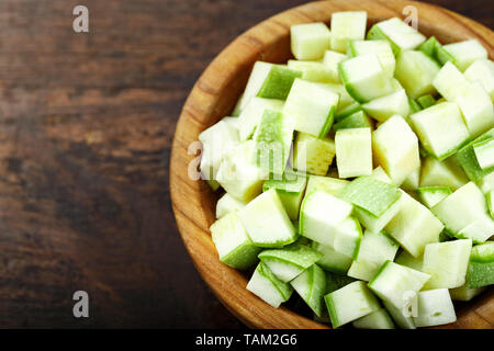 Gewürfelte Zucchini in eine Platte auf einem hölzernen Hintergrund. Platz für Text Stockfoto