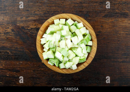 Gewürfelte Zucchini in eine Platte auf einem hölzernen Hintergrund. Platz für Text Stockfoto
