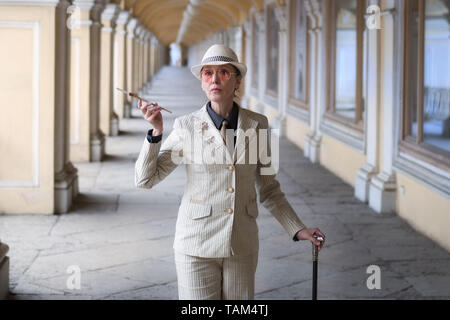 Ältere Frau in einem Anzug mit Hut mit einem Stock und eine Zigarette. Business Woman Stockfoto