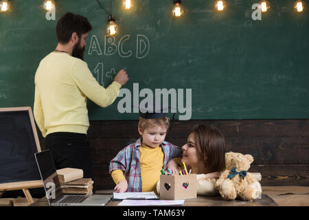 Junge hören mit Aufmerksamkeit zu Mama. Homeschooling Konzept. Familie kümmert sich um Erziehung ihrer kleinen Smart Sohn. Mutter lehrt kluger Sohn, während Stockfoto