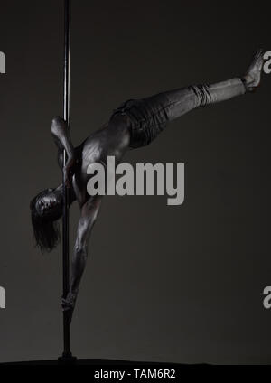 Athletischer Mann auf Pylon. athletischer Mann mit silber lackierte Karosserie. Stockfoto