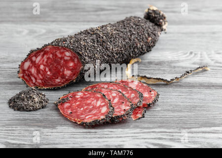 Stücke von geräucherten Würstchen auf einem grauen Tabelle. Stockfoto