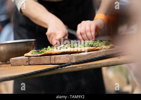 Rachel De Thample demonstrieren outdoor Feuerstelle kochen, vorbereiten, einen sauren Teig Pizza. River Cottage Essen Messe. Devon. 2019 Stockfoto