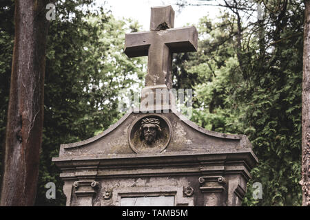 Burial vault auf dem Friedhof, ein grosses Steinkreuz, das Bild von Jesus auf der Beerdigung Vault. Altes Grab. Stockfoto