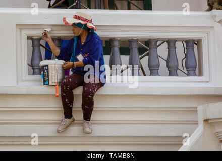 Frau sitzt auf der Kante der Malerei ein Balkon an der Grand Palace in Bangkok, Thailand Stockfoto