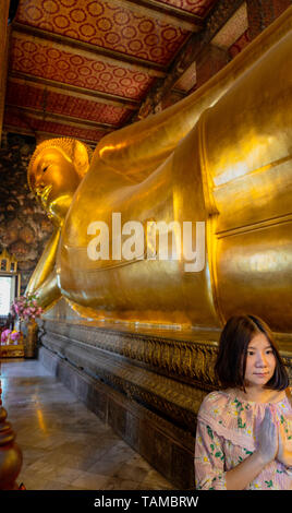 Frau betet vor der liegende Buddha im Wat Pho Tempel, Bangkok, Thailand Stockfoto