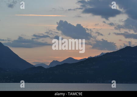 Schönen Sonnenuntergang am Comer See im Frühjahr und Panoramablick nach Menaggio Bergkette von Bellano. Stockfoto