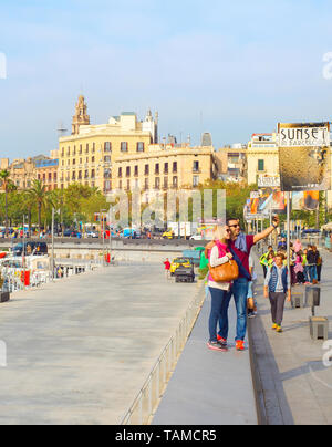 BARCELONA, Spanien - 3. NOVEMBER 2016: Paar unter selfie mit Smartphone auf Barcelona Damm von Marina mit Yachten in der Abendsonne, Spanien Stockfoto