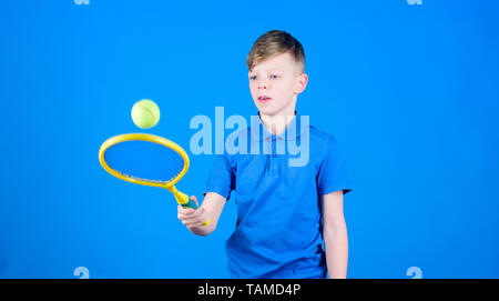 Athlet kid Tennisschläger auf blauem Hintergrund. Tennis Sport und Unterhaltung. Junge Kind Tennis spielen. Tennis Fähigkeiten zu üben. Kerl mit Schläger genießen Spiel. Zukünftige Meister. Träumen über Sport Karriere. Stockfoto