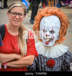 London, Großbritannien. 26 Mai, 2019. Eine Mutter sieht irritiert, dass ihre junge Tochter entschieden hat, als Horror Charakter" Pennywise' von 'ES' MCM Comicon der dritte und letzte Tag wieder einmal Tausende von cosplayer und Fans der Comics, Spiele und Sci-fi und Fantasy in fantastischen Kostümen und Outfits auf ExCel London sieht Ihre Lieblingsfiguren zu feiern. Credit: Imageplotter/Alamy leben Nachrichten Stockfoto