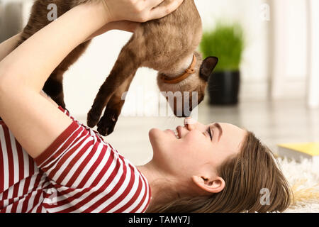 Junge Frau mit niedlichen lustig Thai Katze zu Hause Stockfoto