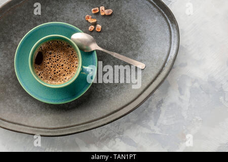Eine Nahaufnahme, eine Tasse schwarzen Kaffee, geschossen von oben auf ein Fach mit karamellisierten Zucker, Löffel, und kopieren Sie Platz Stockfoto