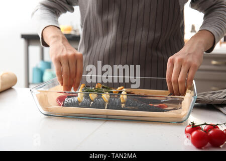 Frau kochen lecker Makrele Fisch in der Küche Stockfoto