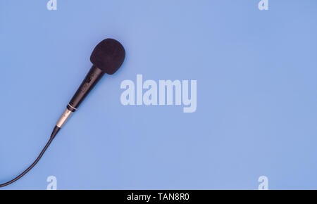 Schwarzes Mikrofon auf blauem Hintergrund für Musik Konzept Stockfoto