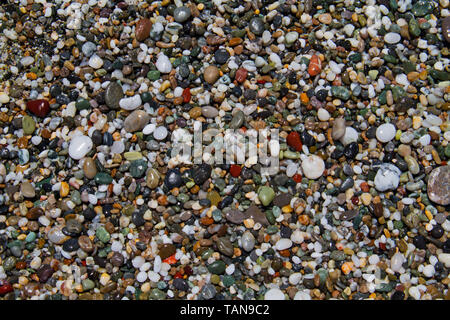 Bunte Kleine abgerundete nassen Kieselsteinen auf einen Kiesstrand Stockfoto