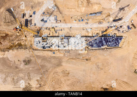Schwere industrielle Maschinen auf der Baustelle arbeiten. neue Wohngebäude im Bau. Luftaufnahme Stockfoto