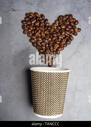 Top Papier anzeigen Coffee to go Becher und Herz aus Kaffeebohnen,, Kopieren, grauer Beton Hintergrund Stockfoto