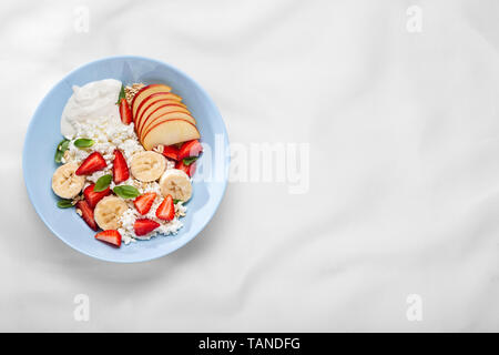 Obstsalat. Obst Dessert mit Sahne, Erdbeeren, Hüttenkäse, Minze und Müsli, Nahaufnahme, Flach. Stockfoto