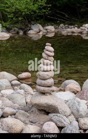 Ausgewogene Steine in der Nähe von einem Fluss und mit dem Wald im Hintergrund stack, Zen Meditation Wellness Entspannung Hintergrund Stockfoto