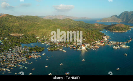 Luftaufnahme Coron Stadt mit Slums und Armenviertel. Hafen, Seebrücke, stadtbild Coron Town mit Booten auf Busuanga Island, Philippinen, Palawan. Marine mit Bergen. Stockfoto