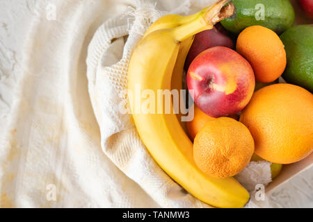 Große Holzkiste mit reifem Obst, Banane, Apfel, Orange, Mandarine, Avocado, vegetarische Essen Stockfoto