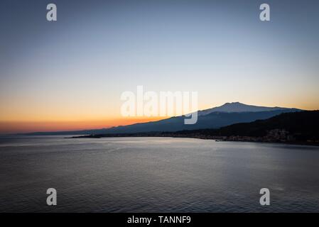 Ruhige Sonnenuntergang über dem Ätna und die tiefen Wasser des Mittelmeers. Stockfoto