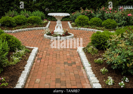 Garten Backyard Backstein Gehweg mit einem Vogelbad in Lancaster County, Pennsylvania, USA, Pa Bilder Frühling Garten Wanderweg, USA Stockfoto