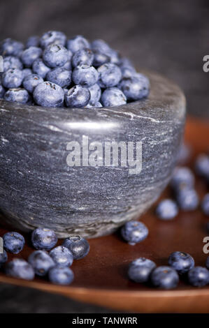 Marmor Schüssel voll mit Blaubeeren auf Holz Fach hautnah. Das gesunde Essen. Selektive konzentrieren. Stockfoto