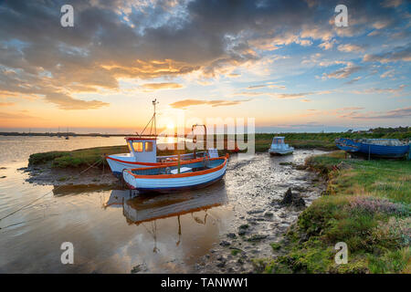 Atemberaubenden Sonnenuntergang über dem alten Fischerboote auf Salzwiesen bei Aldeburgh an der Küste von Suffolk Stockfoto