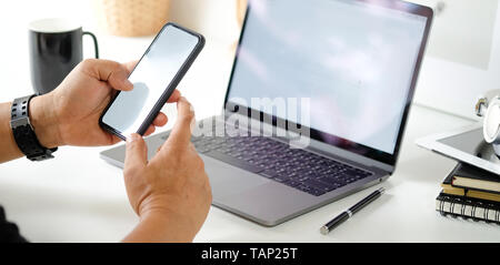 Mann mit Mobile Smartphone in Arbeitsbereich Stockfoto