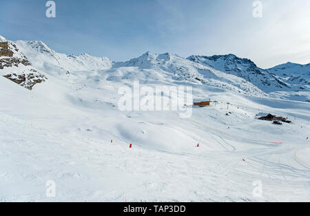 Panoramablick auf die verschneite Tal über Piste in Alpine Mountain Range am blauen Himmel Hintergrund Stockfoto