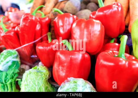 Große Reifen roten süßen Paprika close-up auf dem Hintergrund von anderen Gemüse werden in Schalen auf dem Markt bei Tageslicht verkauft. Stockfoto