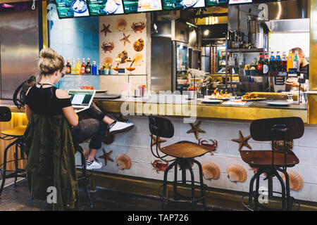 Moskau, Russland - Mai 24, 2019: Junge Frau am Computer in einem Café. Lifestyle Fashion Concept. Stockfoto