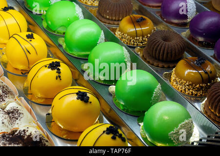 Kuchen in einer Konditorei. Vitrine mit Kuchen, Torten, Süßspeisen. Trandy souffle Kuchen. Close Up. Stockfoto