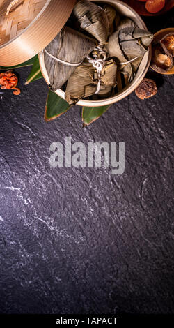 Zongzi, köstliche gedämpftem Reis Knödel in der Dampfeinheit in schwarzen Hintergrund für Drachenboot Festival duanwu, Nahaufnahme, Kopieren, Ansicht von oben, flach Stockfoto