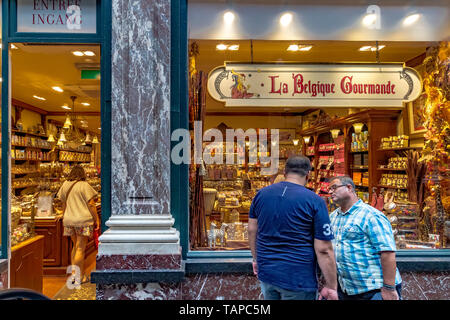 Zwei Männer außerhalb La Belgique Gourmande ein Luxus Schokolade shop in Les Galeries Royales Saint-Hubert, einem eleganten verglaste Einkaufspassage in Brüssel Stockfoto