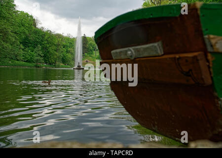 Alten hölzernen Boot Stern auf dem Fluss und Brunnen hinter sich. Stockfoto