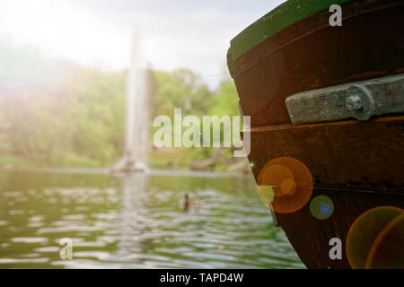Alten hölzernen Boot Stern auf dem Fluss und Brunnen hinter sich. Stockfoto
