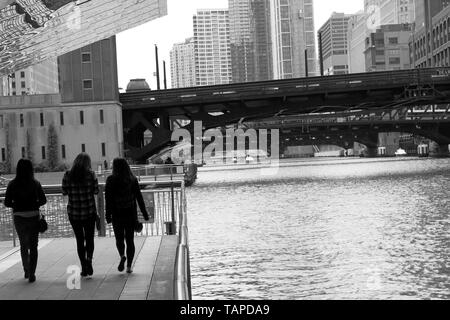 Drei Menschen zu Fuß auf den Riverwalk auf dem Chicago River in Downtown Loop, Chicago, Illinois, USA Stockfoto