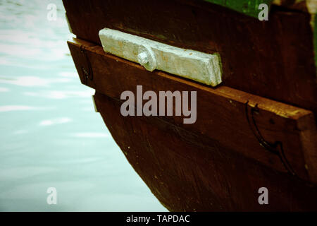 Alten hölzernen Boot Stern auf dem Fluss und Brunnen hinter sich. Stockfoto