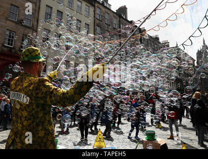 Kinder versuchen, Blasen von einer Straße Interpret auf Feiertag Montag zu verfangen, entlang der der Royal Mile in Edinburgh. Stockfoto