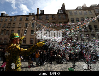 Kinder versuchen, Blasen von einer Straße Interpret auf Feiertag Montag zu verfangen, entlang der der Royal Mile in Edinburgh. Stockfoto