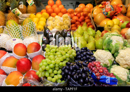 Heller Hintergrund von frischen Früchten, grün schwarz roten Beeren der Trauben, Mango, Birnen, Äpfel, Ananas, Melone liegen in die Fächer, die in der Markt- und attraktive Stockfoto