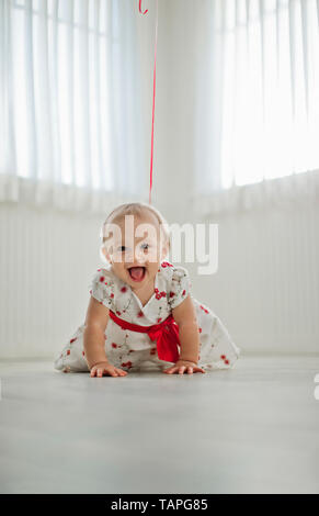 Porträt eines lächelnden Mädchen kriecht auf dem Boden. Stockfoto
