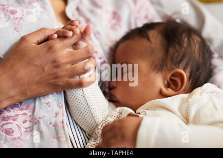 Nahaufnahme der unkenntlich Afrikanische Mutter Holding baby Sohn und seine kleine Hand, Bonding zwischen Mutter und Kind Stockfoto