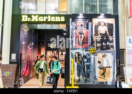 Zwei glückliche Erwachsene Männer verlassen Dr Martens Schuh und Boot store in Shimotori Einkaufspassage, Kumamoto, Japan. Night Shot, Außen von Shop- und Eingang. Stockfoto