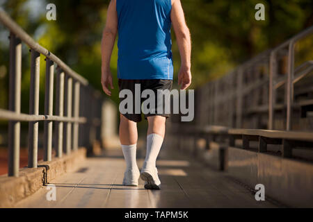 Ältere Menschen gehen über zuschauertribünen in Turnschuhen. Stockfoto