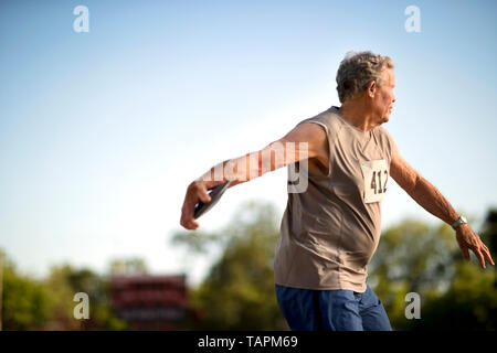 Reifer mann Ziel mit einem Discus konzentriert. Stockfoto